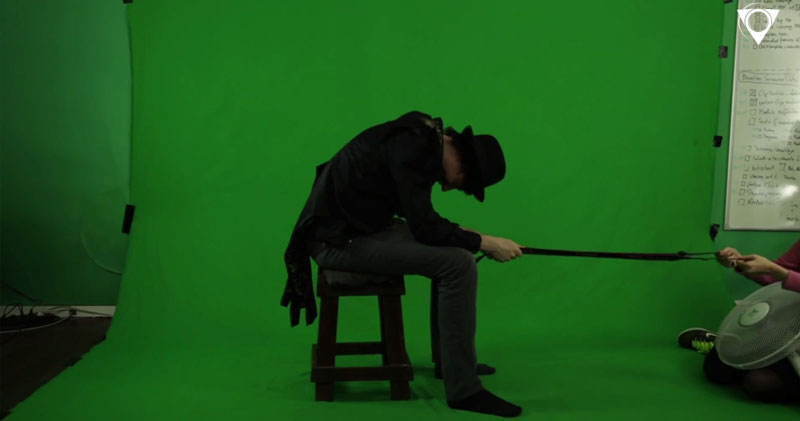 Man sitting in front of a Greenscreen